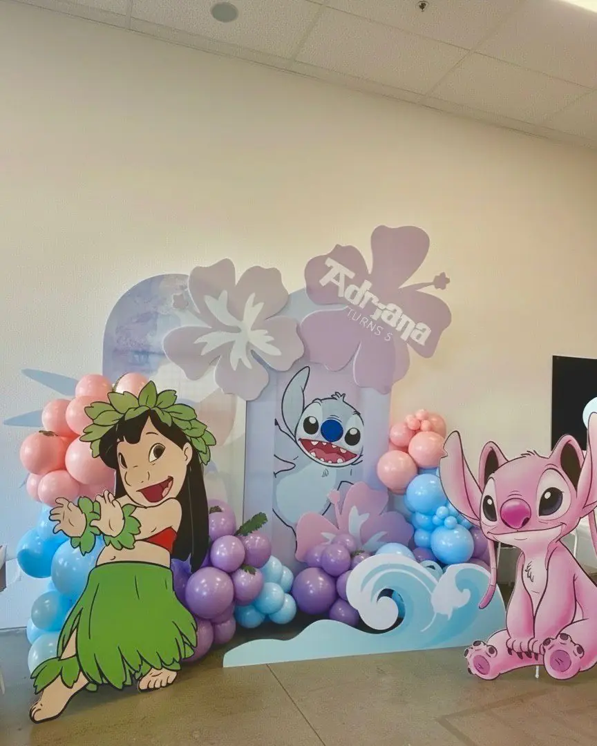 Lilo and Stitch themed party backdrop with character cutouts and pastel balloon garlands for kids birthday party rental in Las Cruces New Mexico